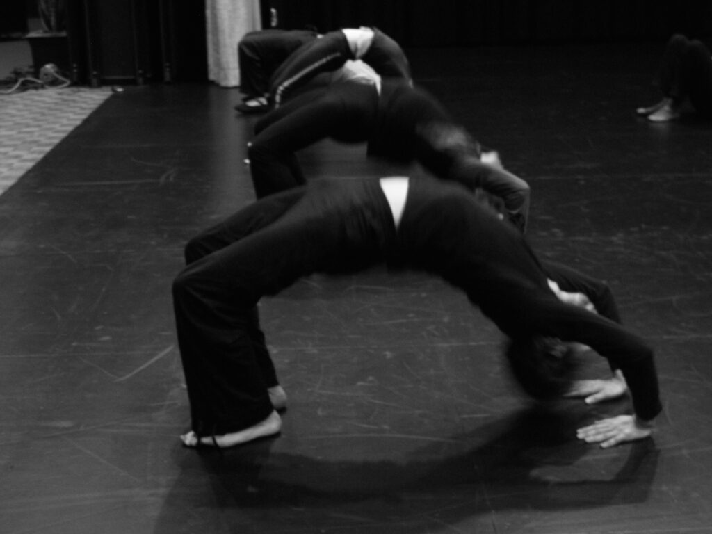 Participants engagés dans un exercice de préparation au théâtre physique, travaillant en studio.